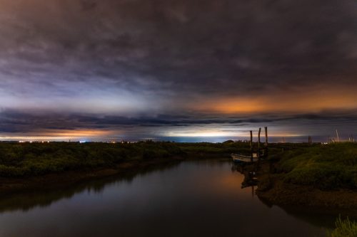 Pollution (La Tremblade, 17) La quiétude du petit port aux huîtres sous un ciel orageux… C’est ce que l’on pourrait penser. En fait, la masse nuageuse fait ici office de réflecteur, accentuant les lumières émises par les lampadaires environnant, dans une palette de couleurs allant des teintes bleutées vers des lumières beaucoup plus chaudes. Aucune activité électrique n’a été enregistrée ce soir là ! Si les nuages ne permettent pas de tirer de beaux clichés des étoiles, ils permettent en revanche de prendre conscience de la pollution lumineuse engendrée par les activités humaines.